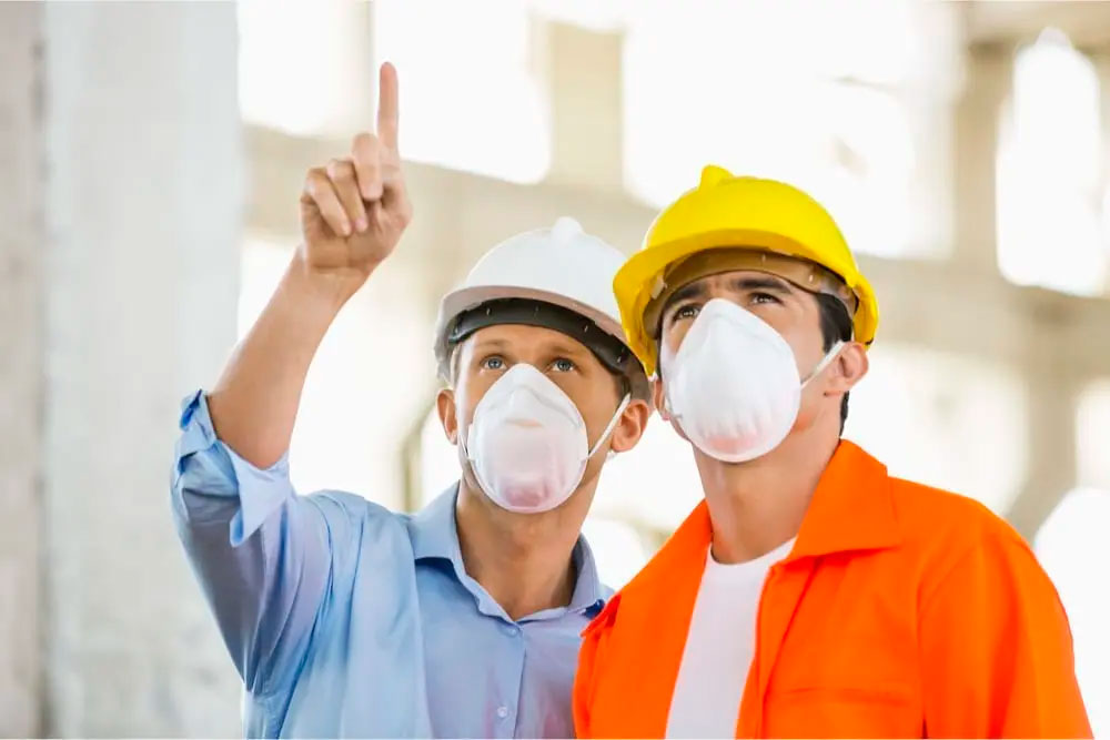 A pair of workers pointing upwards on a construction site and know How Coronavirus is Schooling Contractors about Insurance
