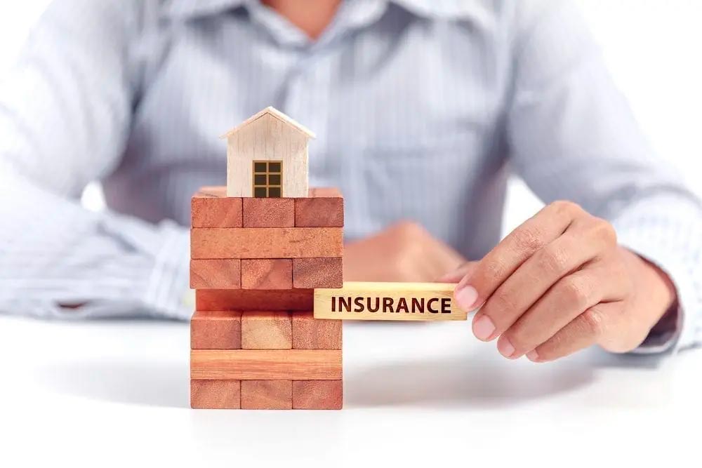 person holding a jigsaw puzzle piece with the word insurance on it