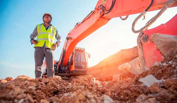 worker beside tractor