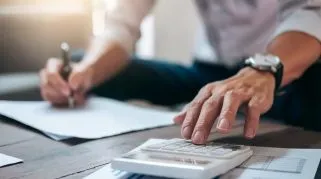 Executive calculating how much you are saving by having contractor liability insurance.