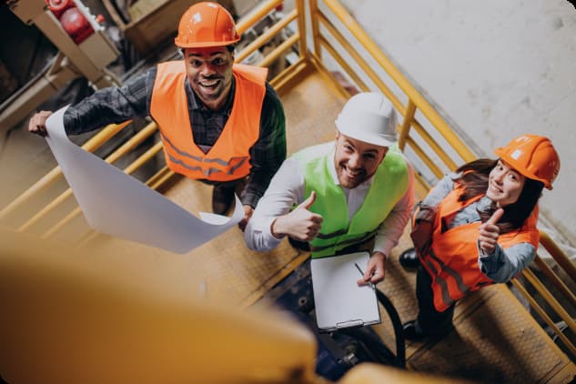 three-factory-workers-safety-hats-discussing-manufacture-plan